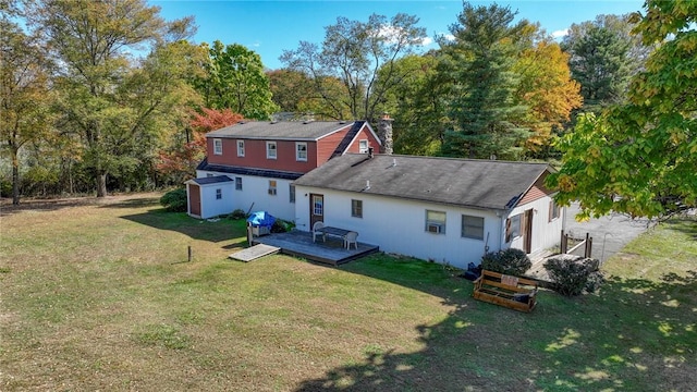 rear view of house with a deck, a shed, and a lawn