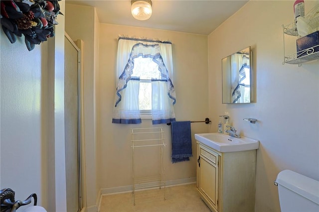 bathroom featuring vanity, an enclosed shower, and toilet