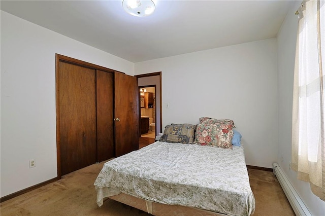 carpeted bedroom featuring a baseboard heating unit and a closet