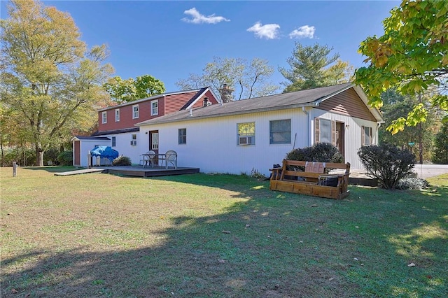 rear view of property featuring a lawn and a deck