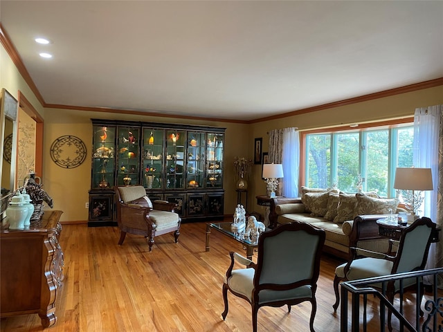 living room with light wood-type flooring and ornamental molding