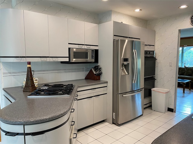 kitchen featuring white cabinetry, stainless steel appliances, and light tile patterned floors