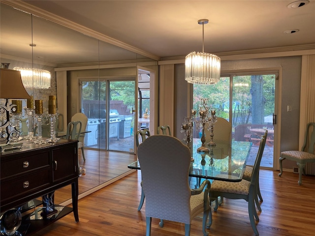 dining space featuring ornamental molding, a chandelier, and light wood-type flooring