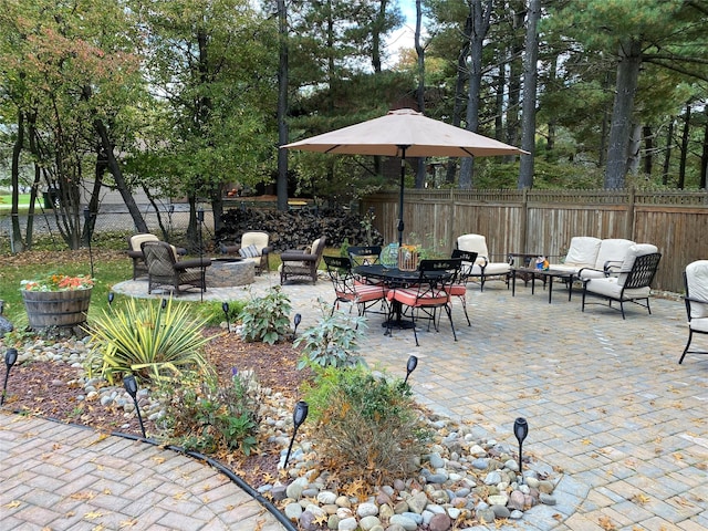 view of patio with an outdoor living space with a fire pit