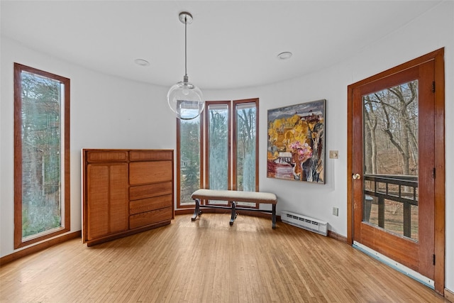 interior space with light wood-type flooring and a baseboard heating unit