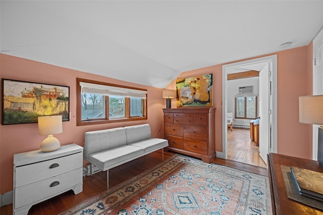 sitting room with baseboard heating, vaulted ceiling, and wood-type flooring