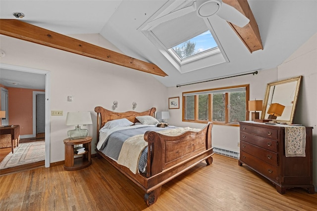 bedroom with ceiling fan, light wood-type flooring, lofted ceiling with skylight, and a baseboard radiator