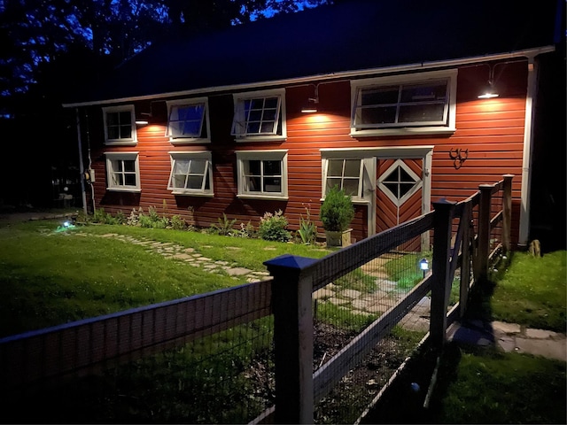 back house at twilight featuring a lawn