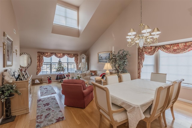 dining space featuring a chandelier, light hardwood / wood-style floors, and a high ceiling