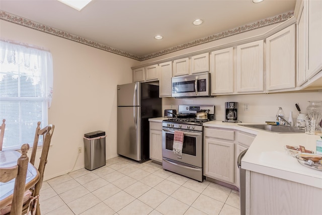 kitchen with light tile patterned flooring, stainless steel appliances, and sink