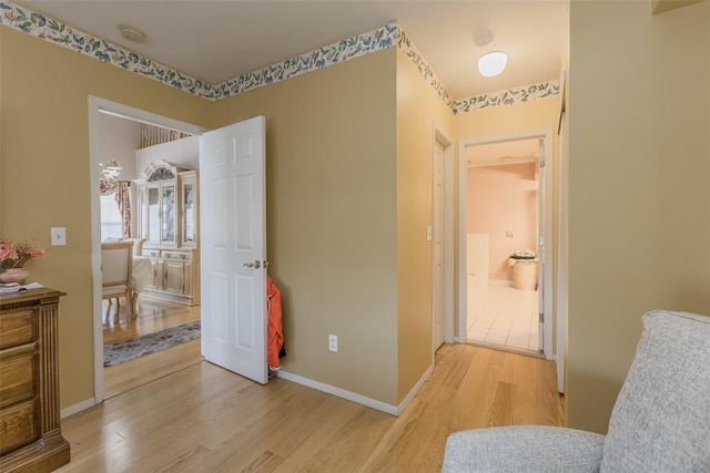 corridor with light hardwood / wood-style floors