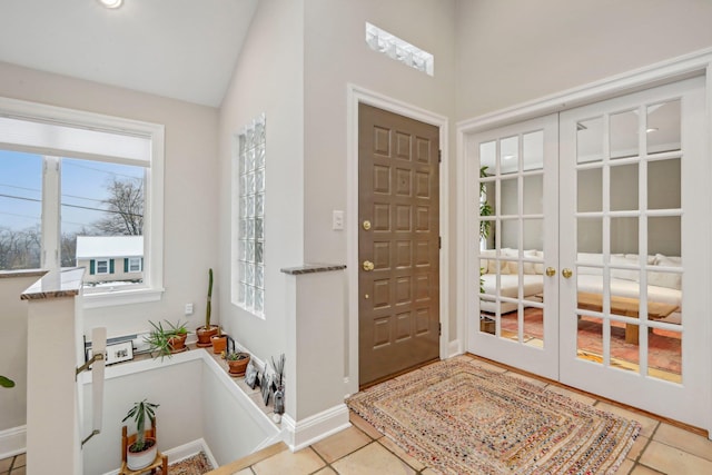 tiled foyer entrance featuring french doors and vaulted ceiling