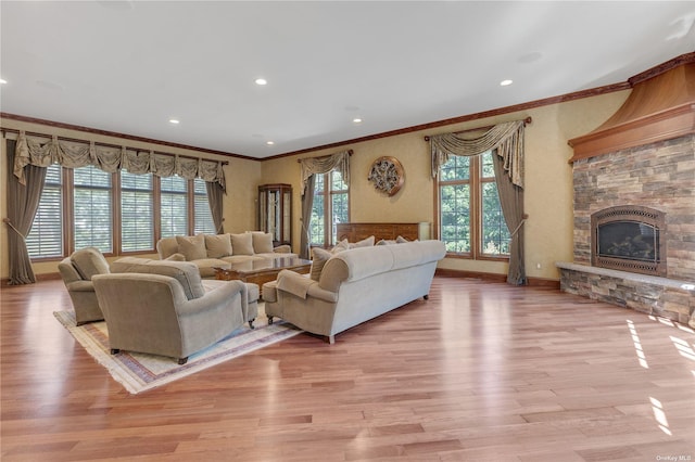 living room with a fireplace, light wood-type flooring, and ornamental molding