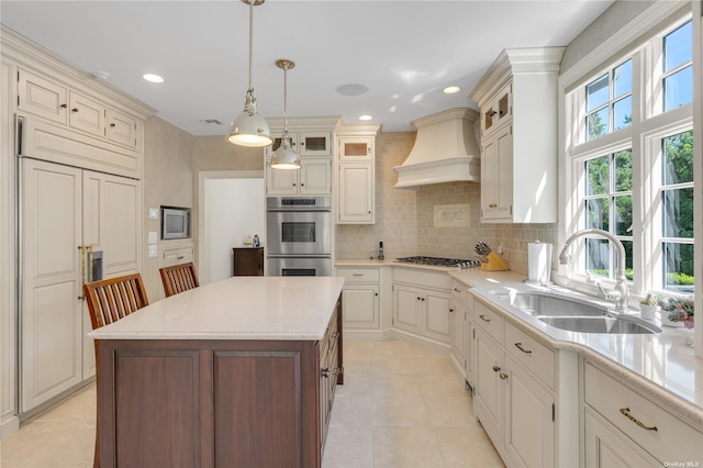 kitchen featuring sink, a center island, hanging light fixtures, stainless steel appliances, and custom range hood