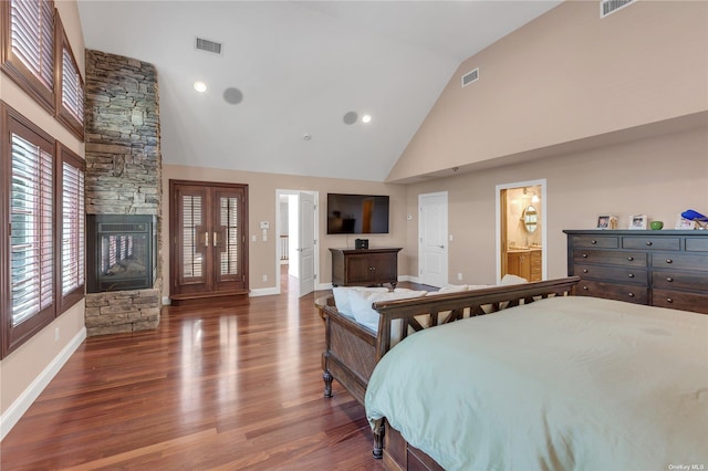 bedroom featuring connected bathroom, a fireplace, high vaulted ceiling, and dark hardwood / wood-style floors