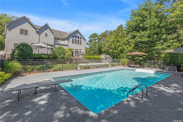 view of pool featuring a diving board and a patio area