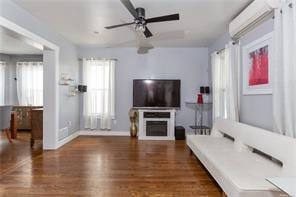 living room with ceiling fan and dark wood-type flooring