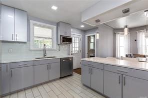 kitchen featuring tasteful backsplash, sink, pendant lighting, and appliances with stainless steel finishes