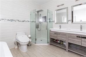 bathroom featuring tile patterned flooring, vanity, toilet, and an enclosed shower