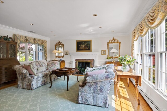 living room featuring crown molding, a baseboard radiator, and a brick fireplace