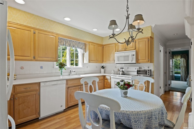 kitchen with light brown cabinetry, white appliances, decorative light fixtures, light hardwood / wood-style flooring, and a notable chandelier