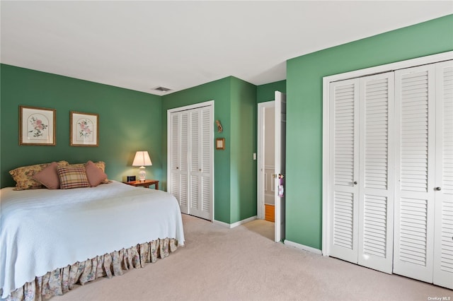 bedroom with light carpet and multiple closets