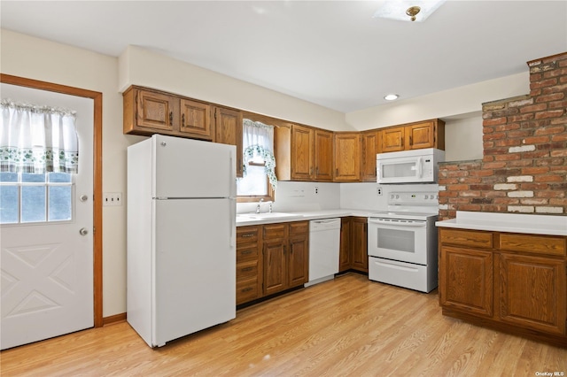 kitchen featuring white appliances, light hardwood / wood-style flooring, and sink