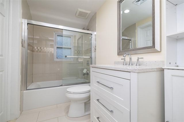 full bathroom featuring toilet, vanity, tile patterned floors, and enclosed tub / shower combo