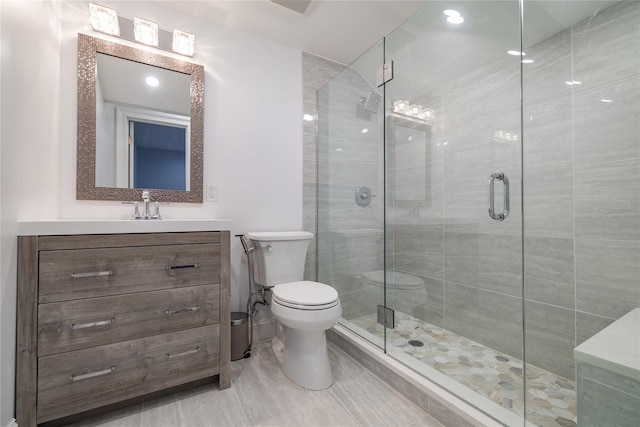 bathroom featuring tile patterned flooring, toilet, an enclosed shower, and vanity