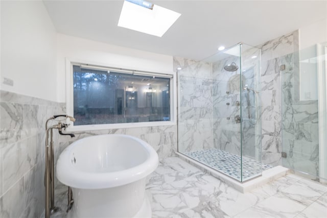 bathroom with a skylight, tile walls, and shower with separate bathtub