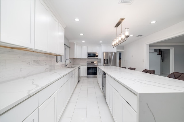 kitchen featuring sink, a kitchen island, tasteful backsplash, white cabinets, and appliances with stainless steel finishes