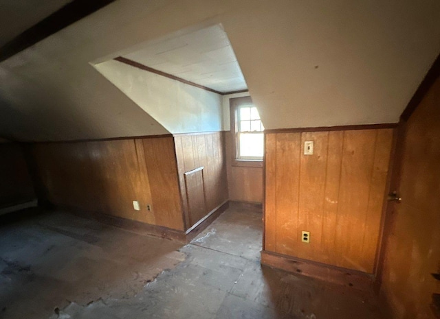 bonus room featuring wood walls