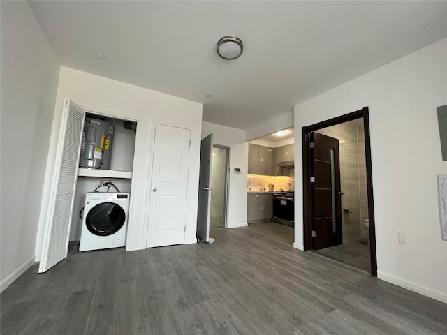 laundry area with dark hardwood / wood-style flooring, washer / clothes dryer, and water heater