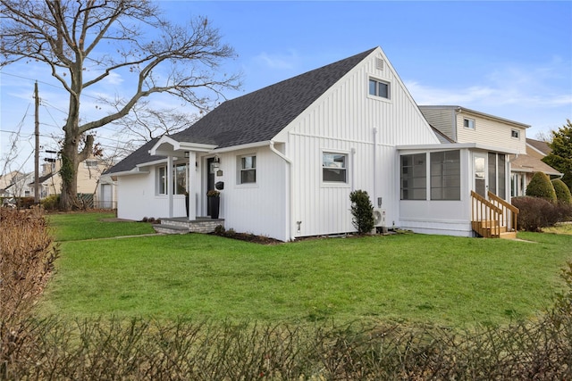 rear view of house with a lawn and a sunroom