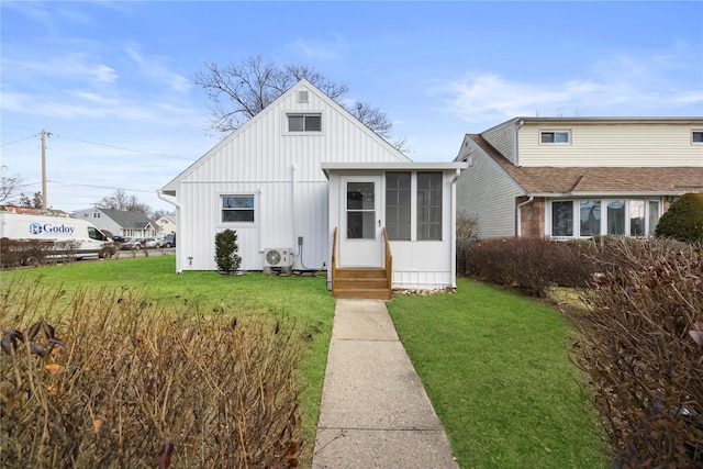 view of front of house featuring a sunroom and a front lawn