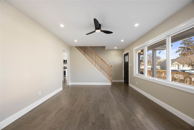 unfurnished living room with ceiling fan and dark wood-type flooring