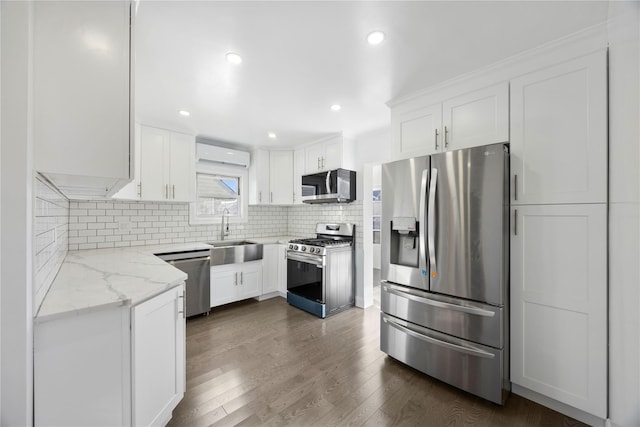 kitchen featuring sink, stainless steel appliances, light stone counters, decorative backsplash, and white cabinets