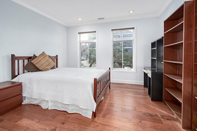 bedroom with hardwood / wood-style flooring and crown molding