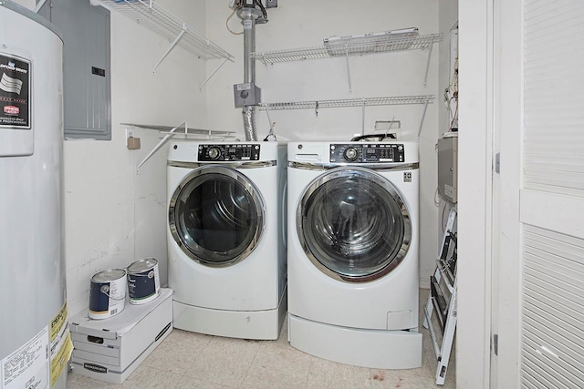 washroom with washing machine and clothes dryer, electric panel, and water heater