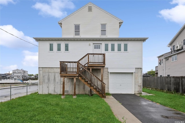 back of property with a garage and a lawn