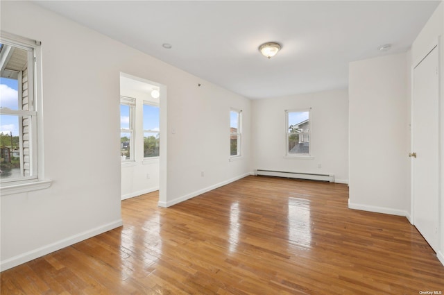 spare room with light wood-type flooring and a baseboard heating unit