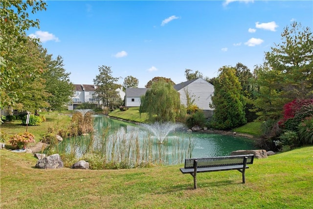 view of home's community featuring a lawn and a water view