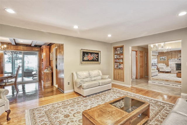 living area featuring a notable chandelier, light wood-style floors, recessed lighting, and baseboards