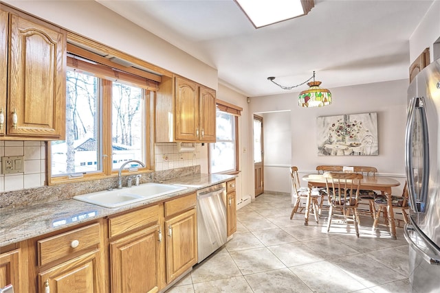 kitchen with tasteful backsplash, light tile patterned flooring, stainless steel appliances, and a sink