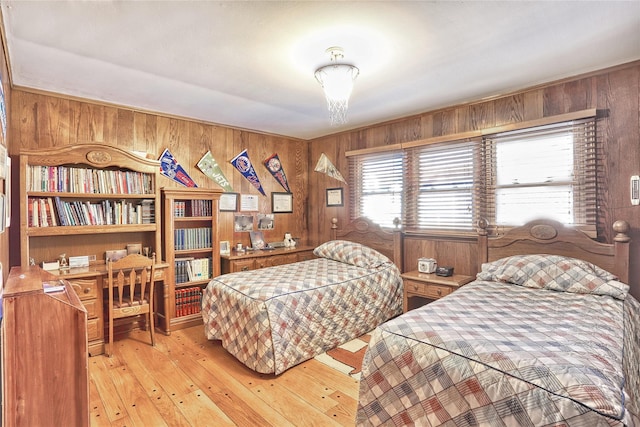 bedroom featuring wood walls and light wood-style floors