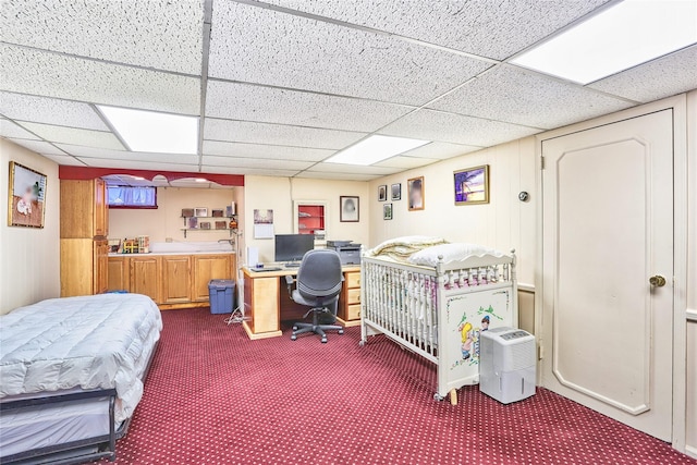 bedroom featuring a drop ceiling and dark carpet