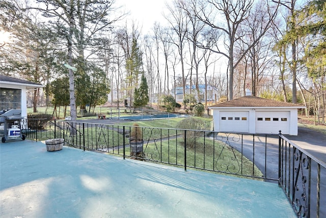 view of patio / terrace featuring a garage, an outbuilding, and fence