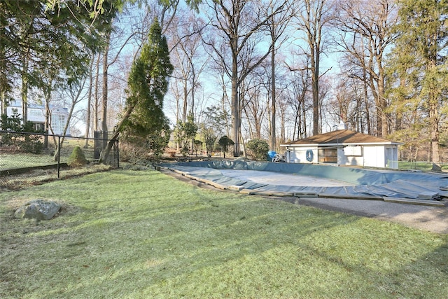 view of yard with an outbuilding, a fenced in pool, and fence