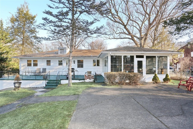 rear view of property featuring a sunroom