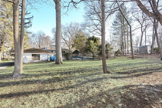 view of yard featuring an outdoor structure and fence